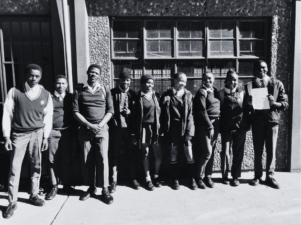 A group of learners outside their school classroom block